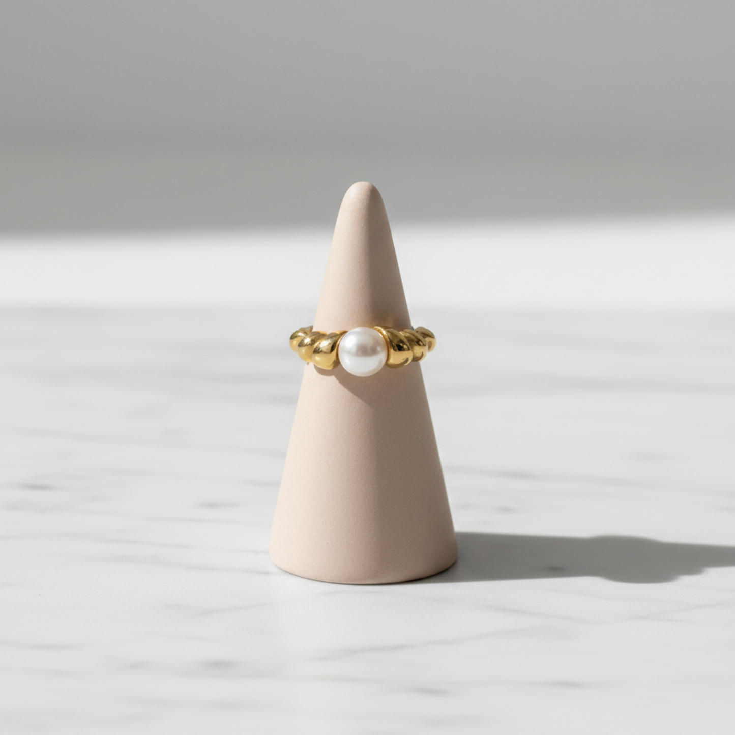 Croissant Pearl Ring displayed on jewelry stand