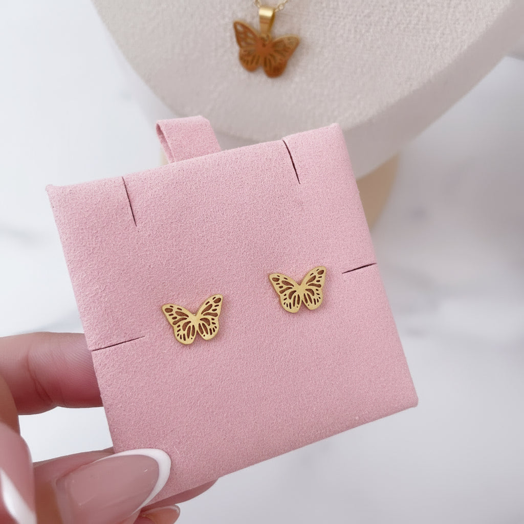 Set de mariposa dorado Vanytel sobre fondo rosa elegante.