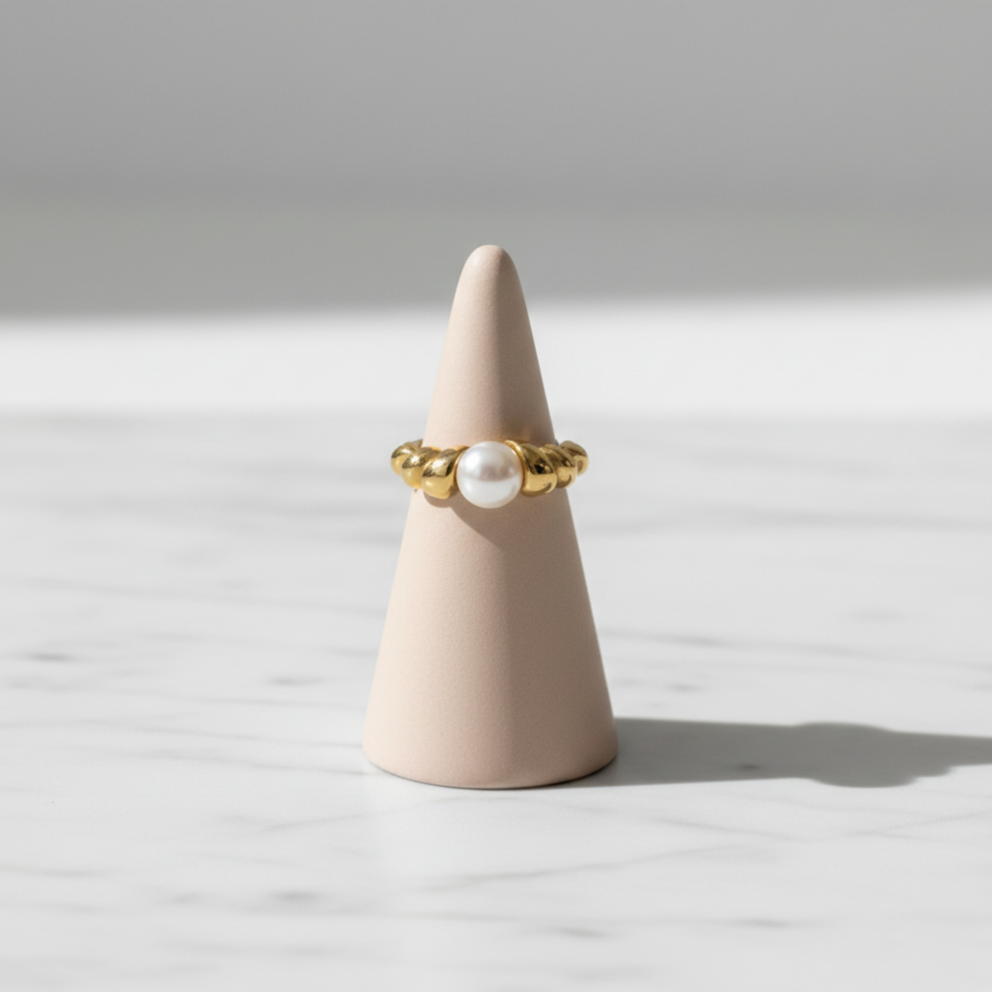 Croissant Pearl Ring displayed on jewelry stand