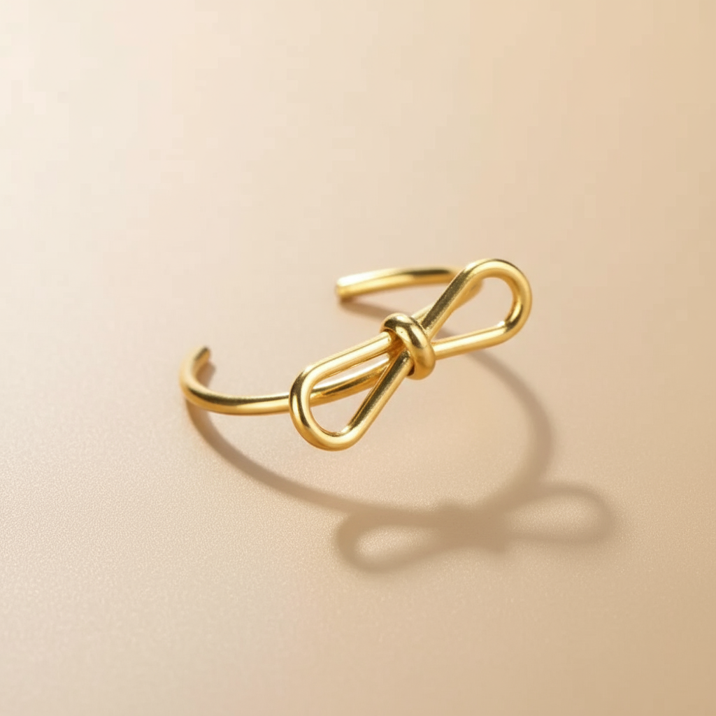 Detalle del Anillo Alicia Vanytel dorado mostrando el diseño de lazo en acero inoxidable.
