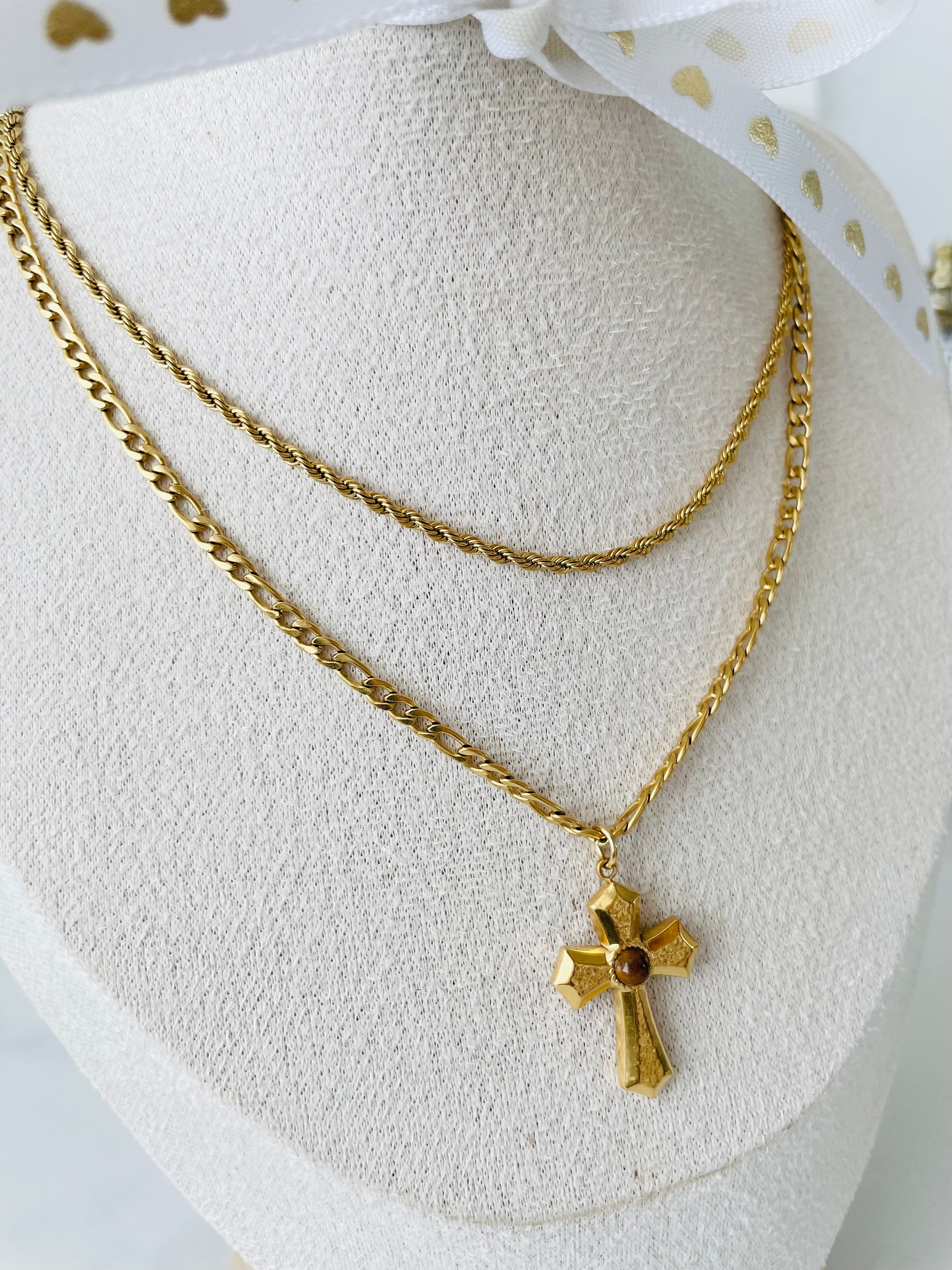 Modelo usando collar doble dorado con cruz, joyería Vanytel