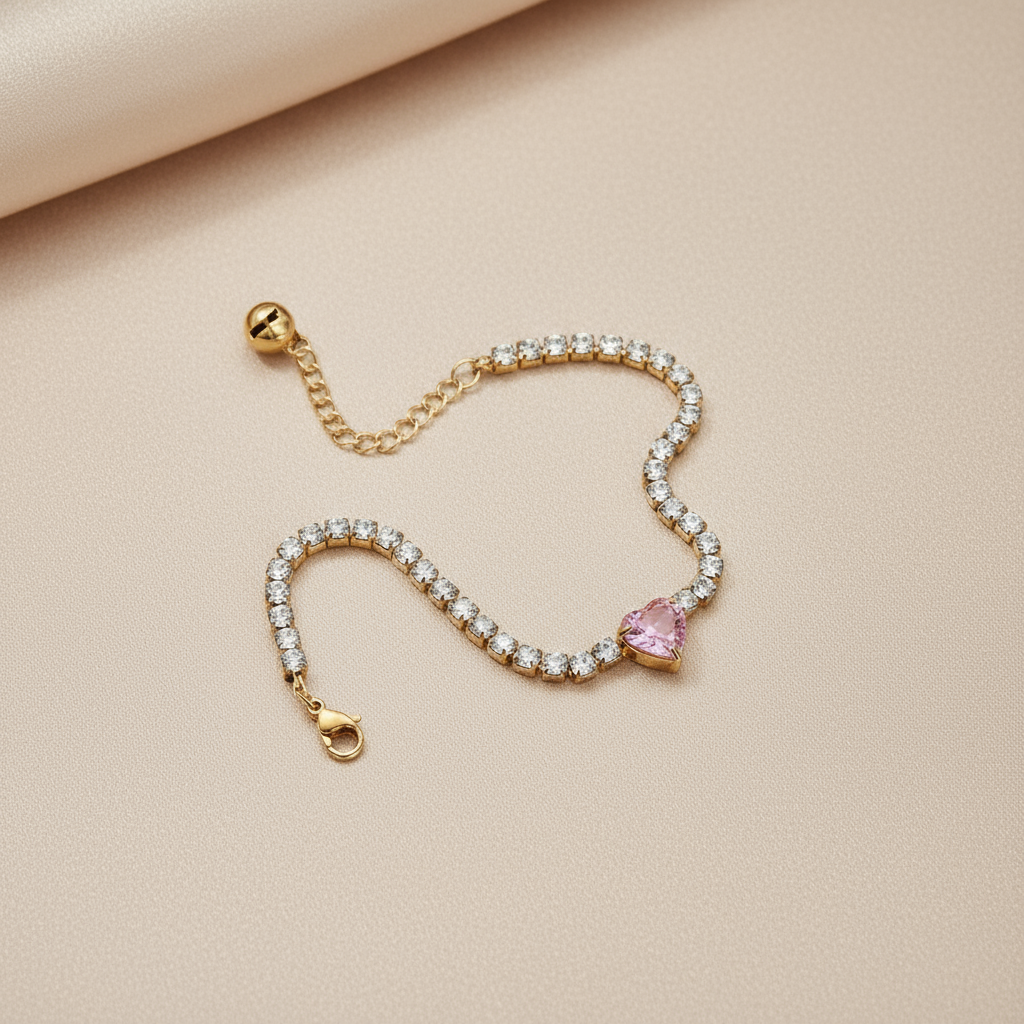 Detalle de la Pulsera Sweet Heart Vanytel sobre superficie beige mostrando el dije de corazón rosa.
