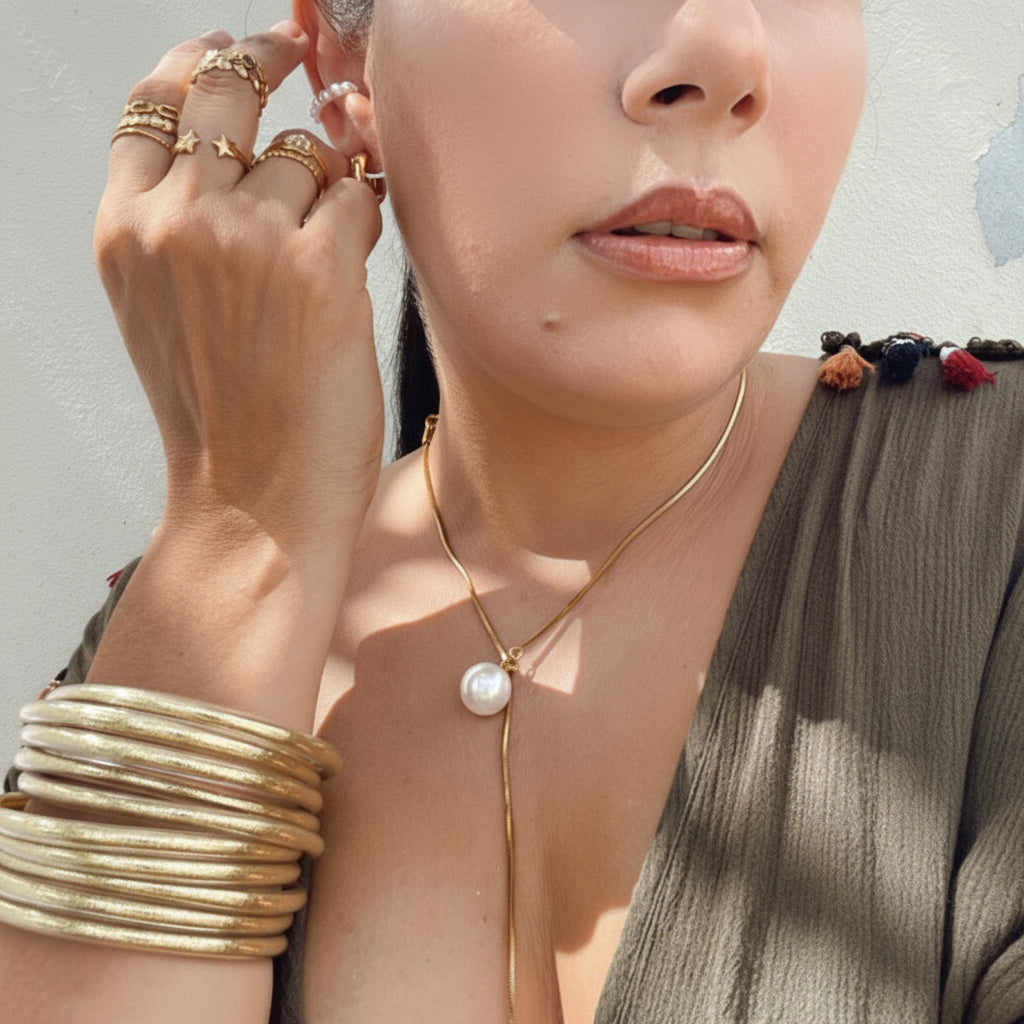 Mujer usando pulseras Jelly Bangles metálicas Vanytel en la playa
